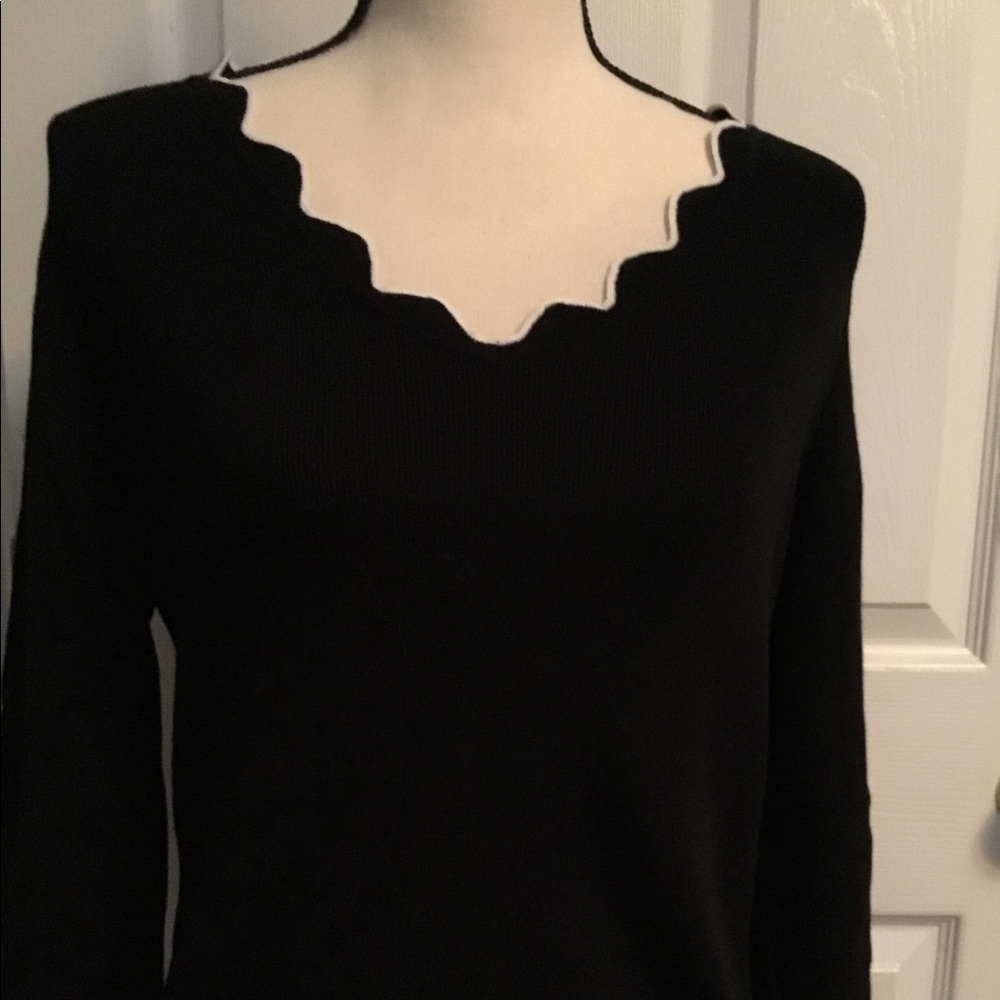 ROZ & ALI knit long sleeved black sweater with white ruffle stitch trim.